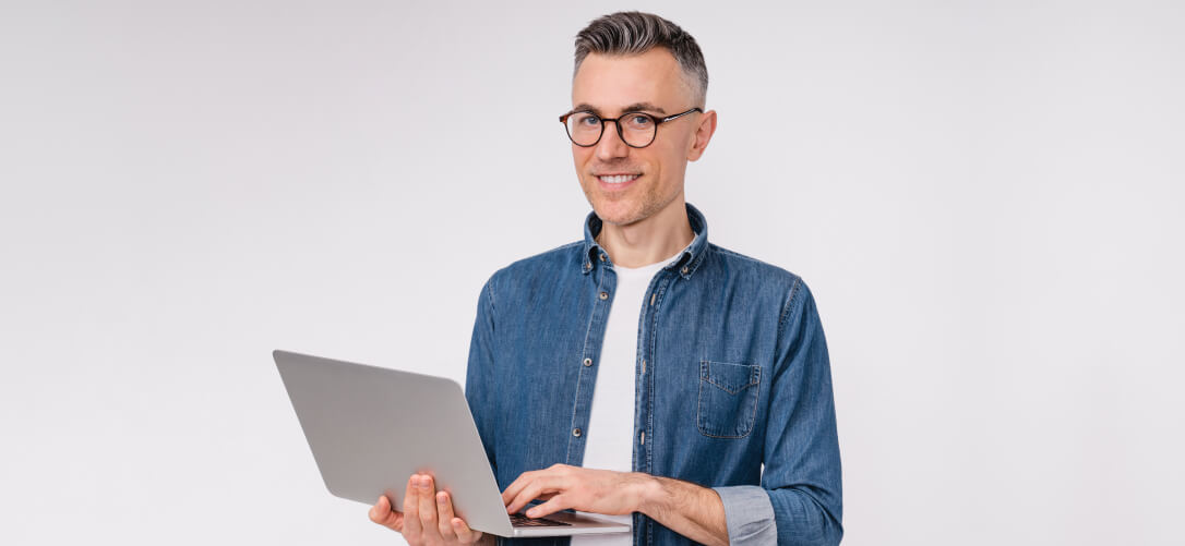 Hombre con lentes sosteniendo un computador con sus manos